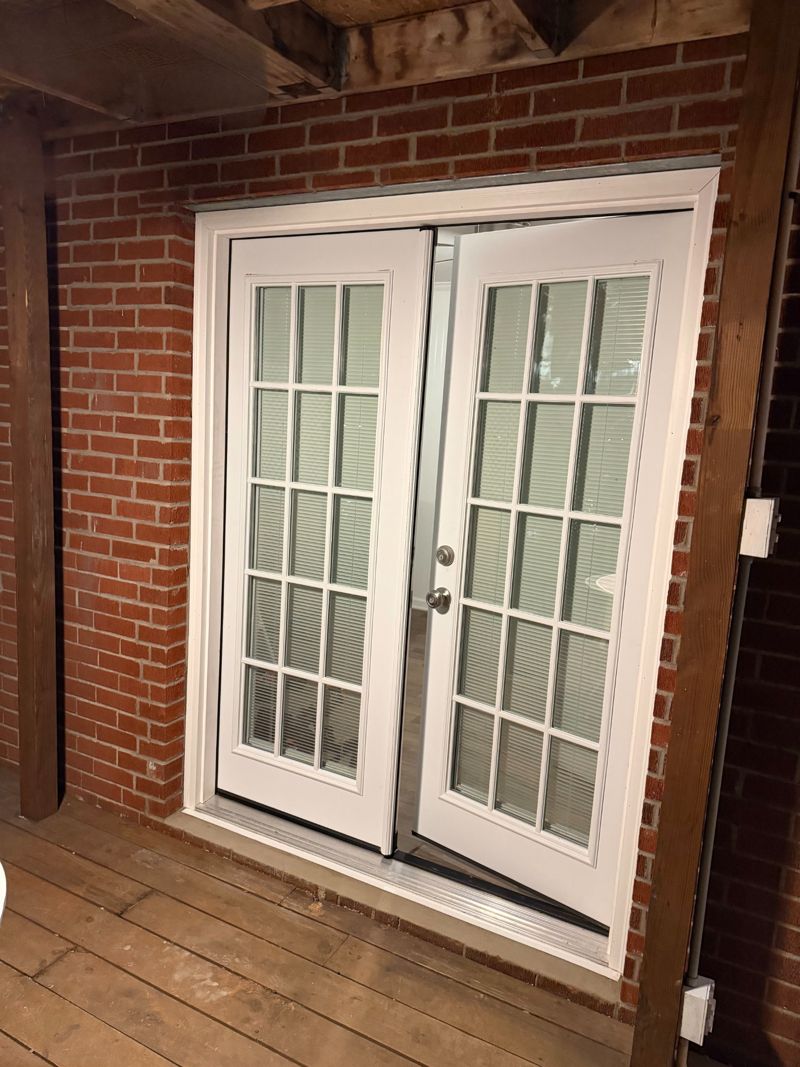 White French doors installed in the enlarged brick opening
