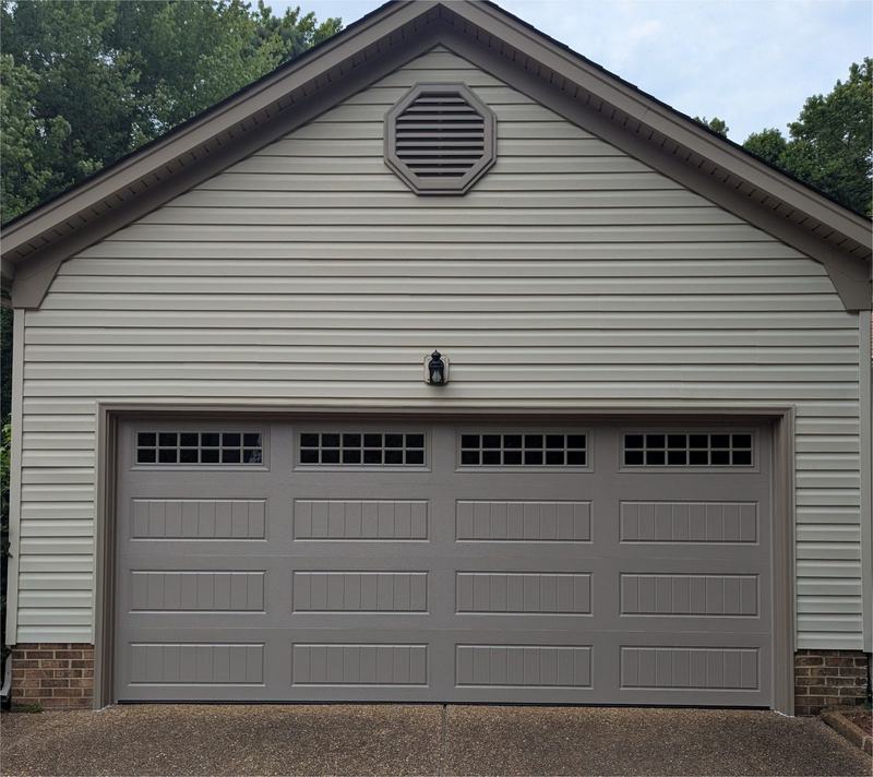 Two-car garage with a taupe paneled garage door with top windows and an octagonal gable vent