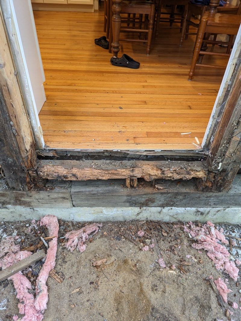 Severely rotted framing below an exterior doorway
