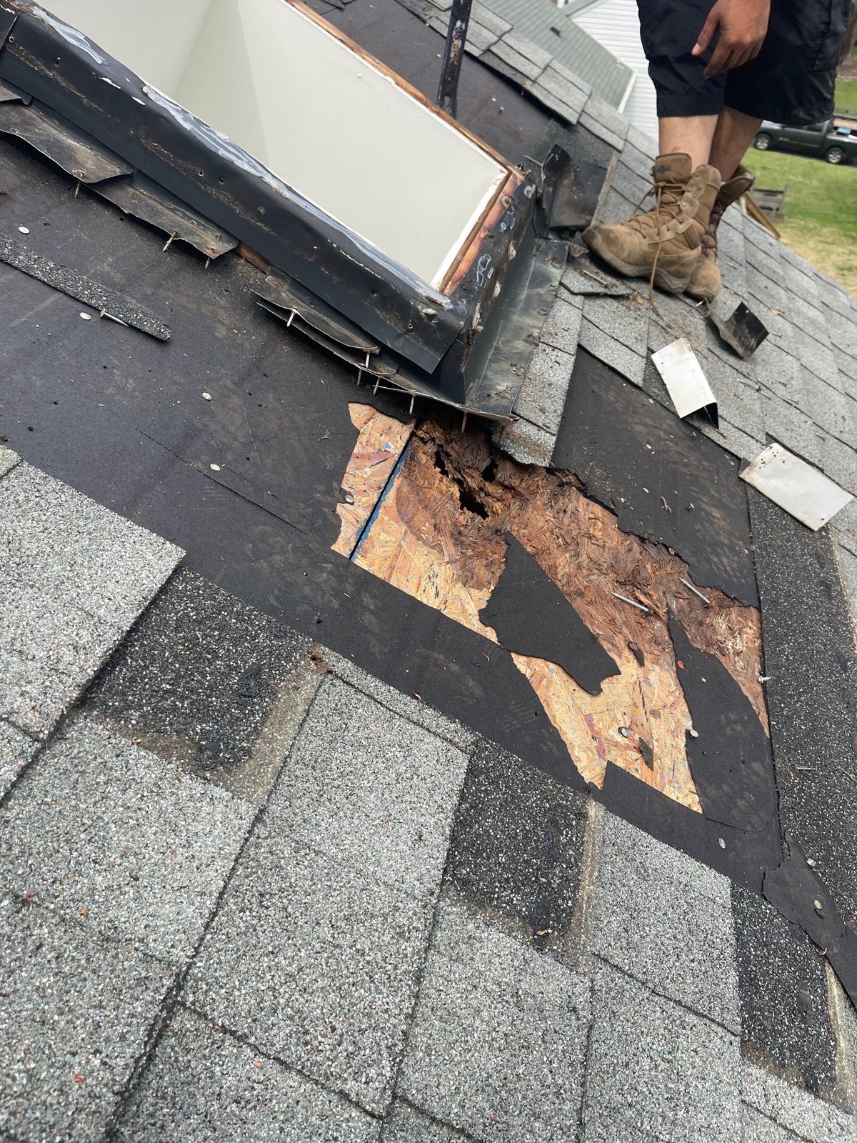 Deteriorated roof sheathing exposed beside a roof opening